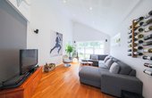 Das Wohnzimmer wird bevorzugt zum Fernsehen genutzt. Auch hier imponiert die Kathedraldecke. (Foto: HausCompagnie / Christoph Große)