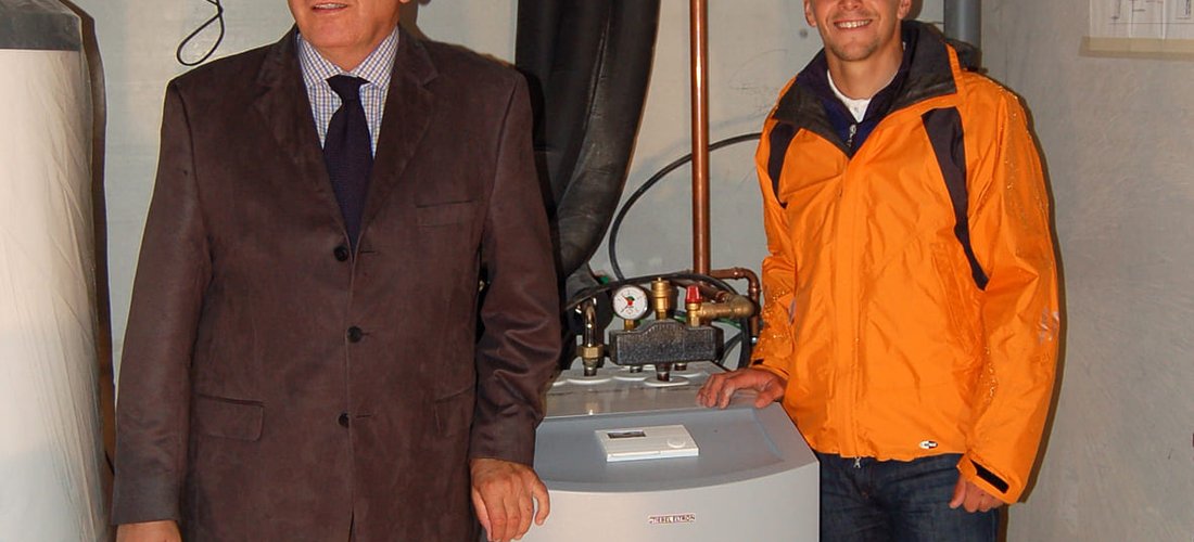 Biathlet Michael Greis (rechts) und Dr. Ulrich Stiebel im Technikraum des Neubaus mit der Wärmepumpenanlage von STIEBEL ELTRON. Foto: Stiebel Eltron 