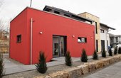 Im Anbauwürfel in Kontrastfarbe rot kann eine Einliegerwohnung oder auch ein Home-Office geplant werden. (Foto: OKAL Haus GmbH)