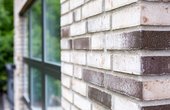 Der kleinformatige Klinker in Beige- und Brauntönen wurde im wilden Verband verarbeitet. Das elegante Fassadenbild harmoniert mit dem Anthrazit des Daches und der Fensterprofile aus Aluminium. Foto: HausCompagnie / Christoph Große)