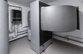 Über einen Luftkanal saugt die innenaufgestellte Luft-Wasser-Wärmepumpe Logatherm WLW196i-14 IRE über ein Gebläse Außenluft an und gibt die Energie an ein Kältemittel in einem Wärmetauscher ab. (Bild: Buderus)