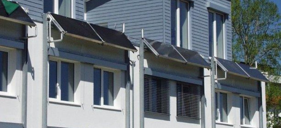 Solarkollektoren decken im Sommer den Brauchwasserbedarf, ein Erdwärme-Nahwärmenetz deckt mit Hilfe einer Wärmepumpe den Restwärmebedarf in den Passiv-Reihenhäusern in Ulm. (Foto: christophers-architekten)